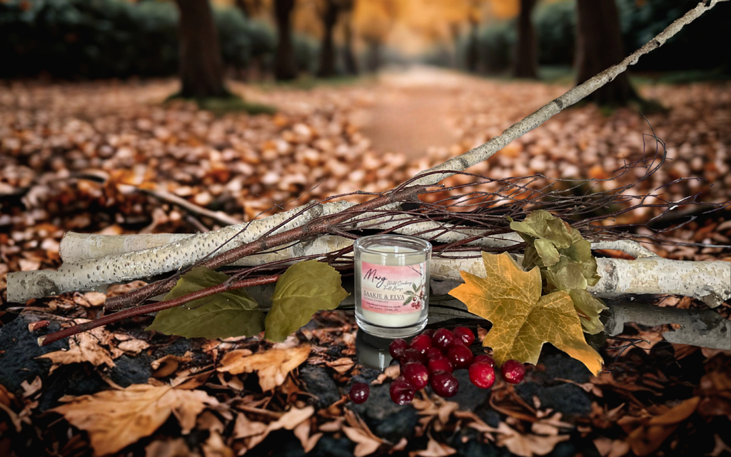 Candle on a branch with autumn leaves and berries in a forest setting